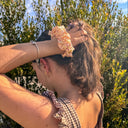 Woman adjusting a headband outdoors with trees in the background